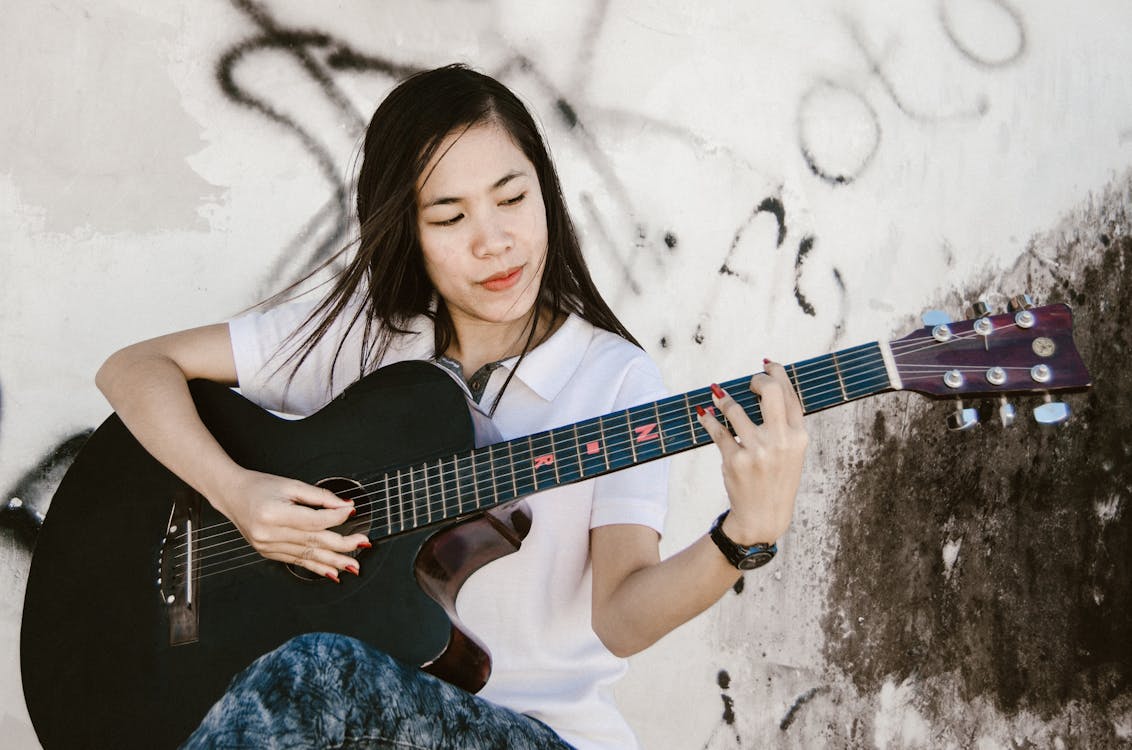 Woman Playing Black Acoustic Guitar