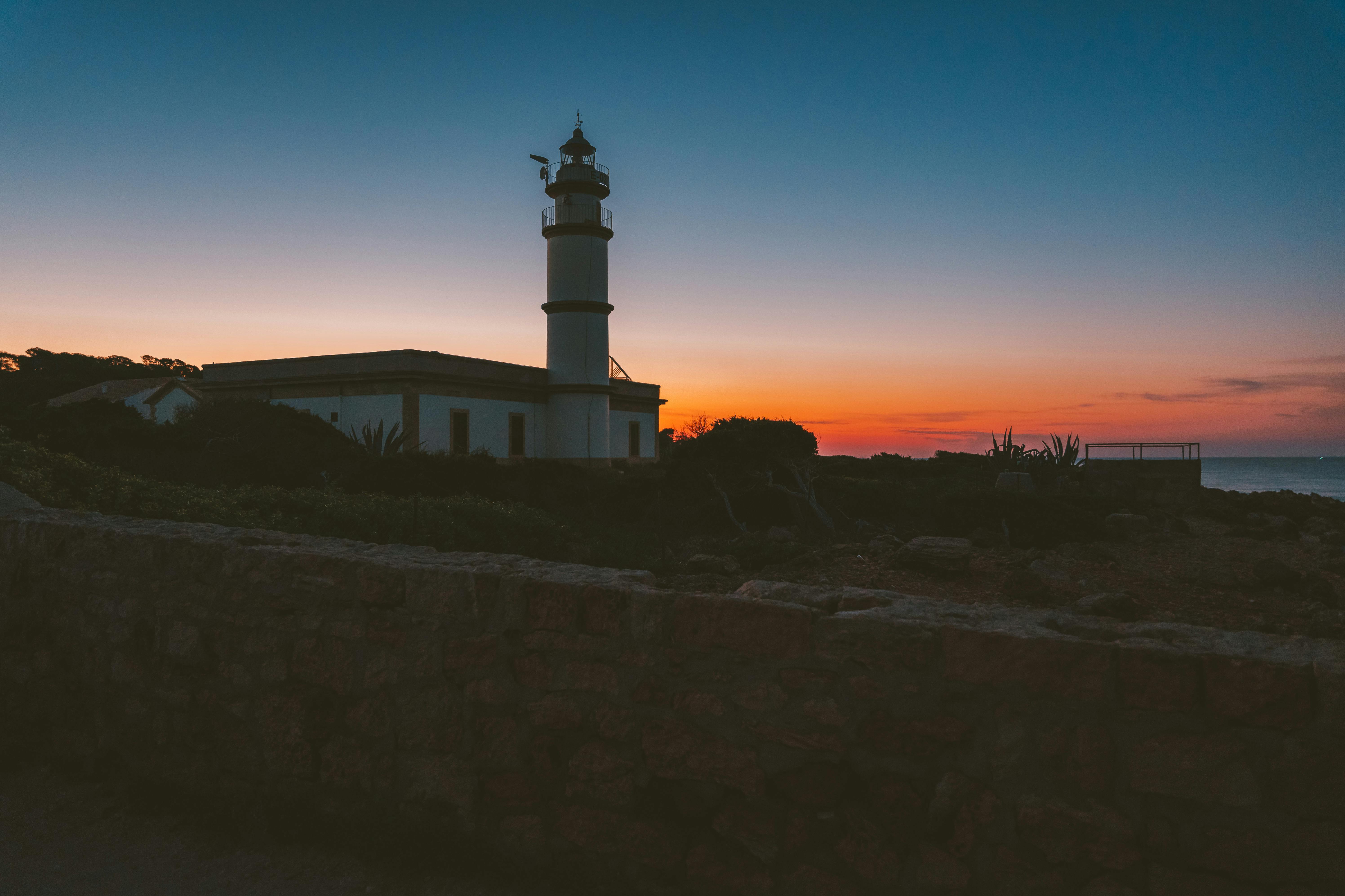 西班牙马略卡岛，日落时分明亮的灯塔轮廓令人惊叹