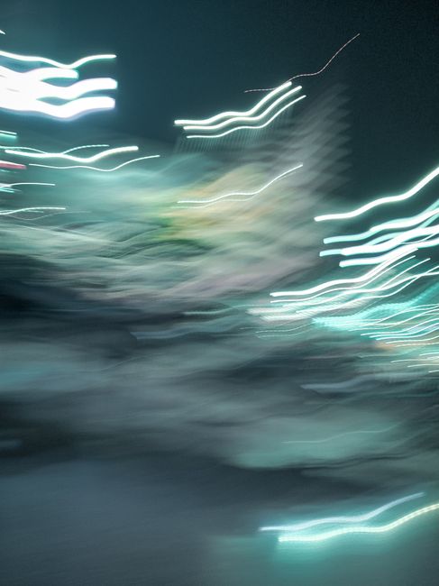 Dynamic light trails create an abstract design against a night city background, emphasizing motion and vibrant urban energy.