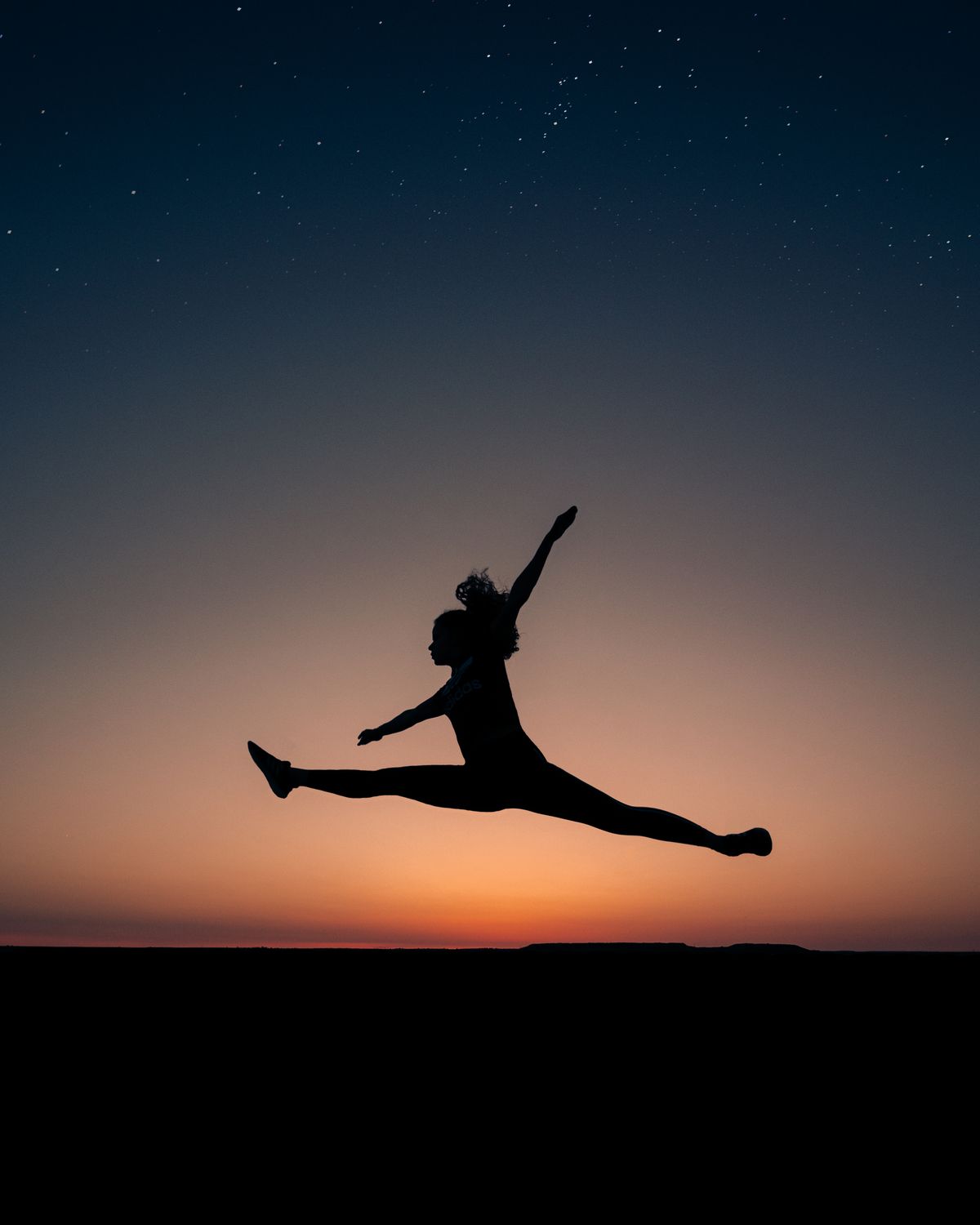Dancer silhouette leaping at dusk