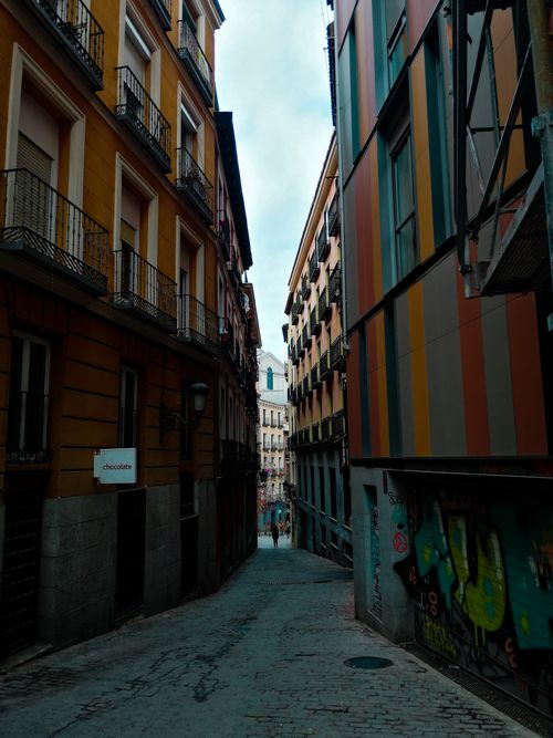 Free Colorful alley in Spain featuring vibrant buildings and historic architecture on a cloudy day. Stock Photo