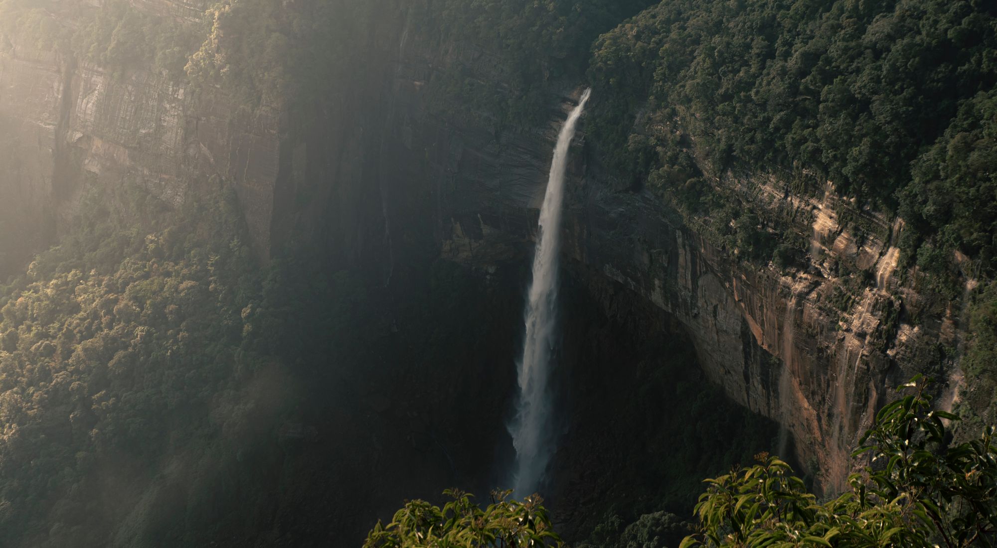 A waterfall cascading down green cliffs