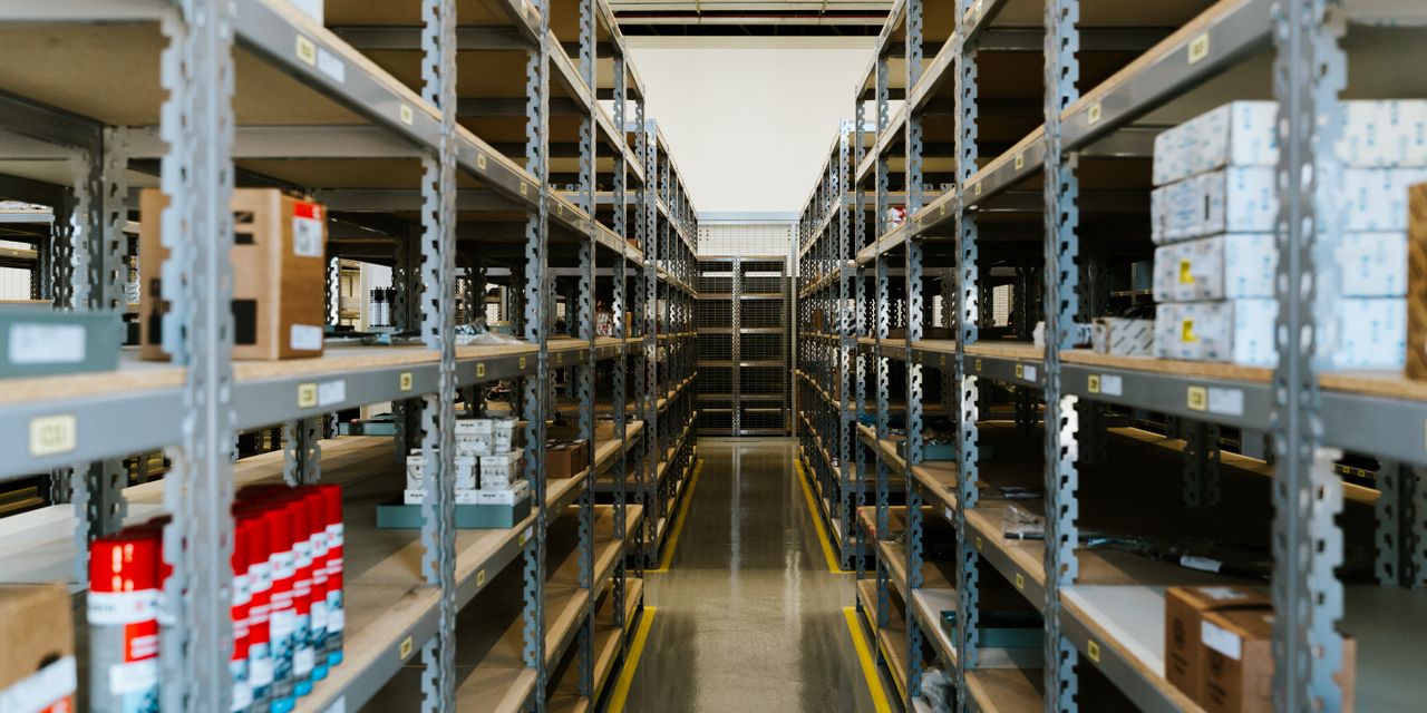 Wide view of an organized industrial warehouse with metal shelving and stored merchandise.