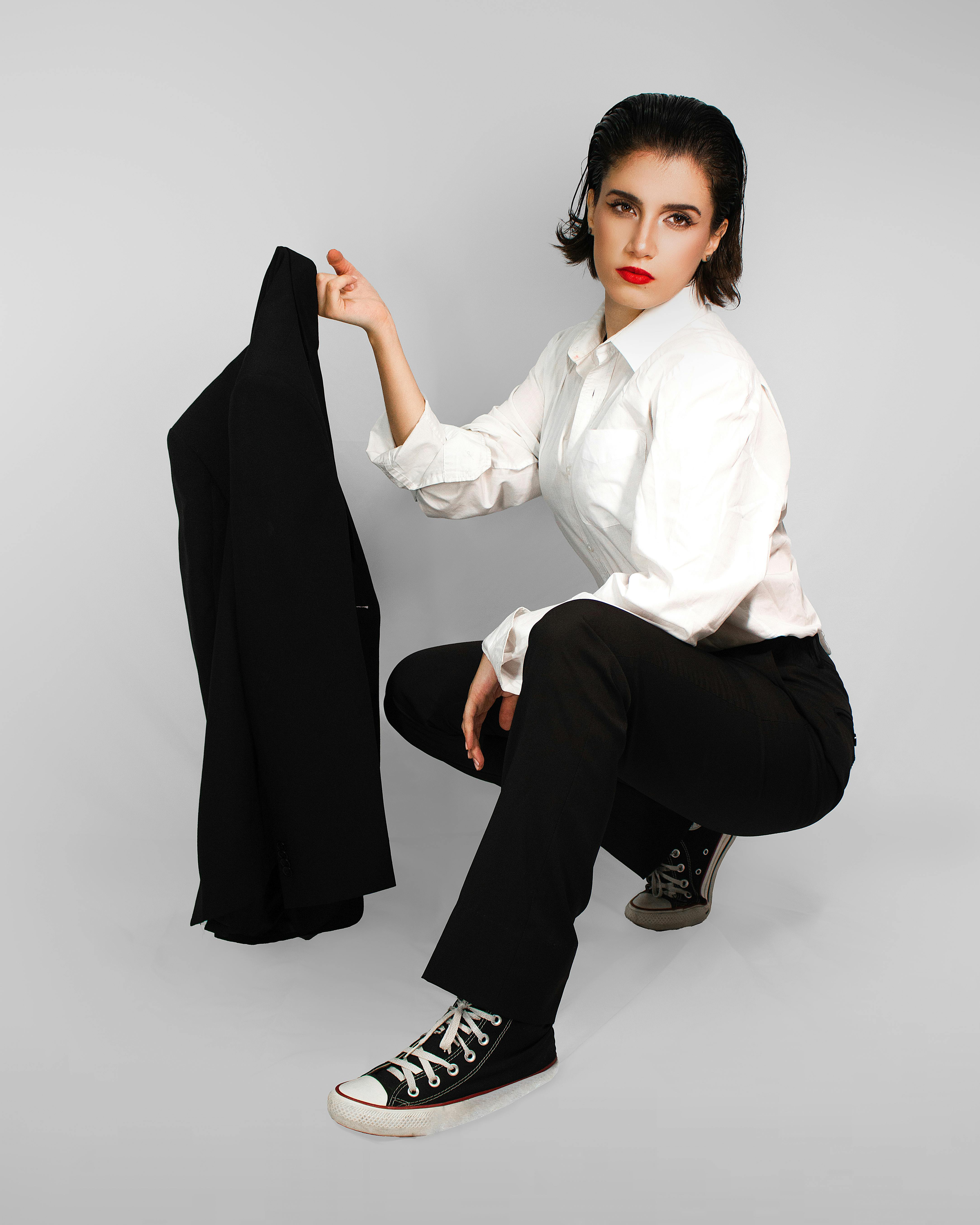 Premium Photo | Woman wearing a white blazer and black pants standing in  front of a wooden wall