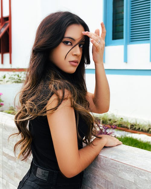 Woman Leaning by the Concrete Railing while Looking at the Camera