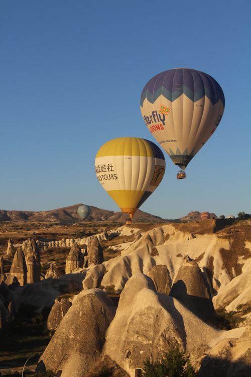 Free Stunning hot air balloons soaring over Cappadocia's unique rock formations at sunrise. Stock Photo