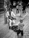 Man and Woman Sitting on Sidewalk