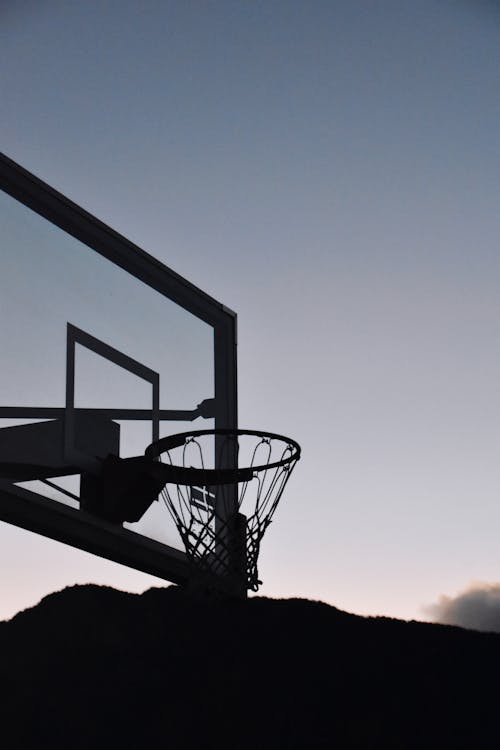 Silhouette of Basketball Hoop Under Evening Sky