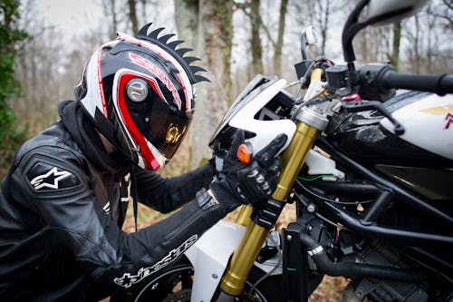 Person in Black and Red Helmet Riding on Motorcycle