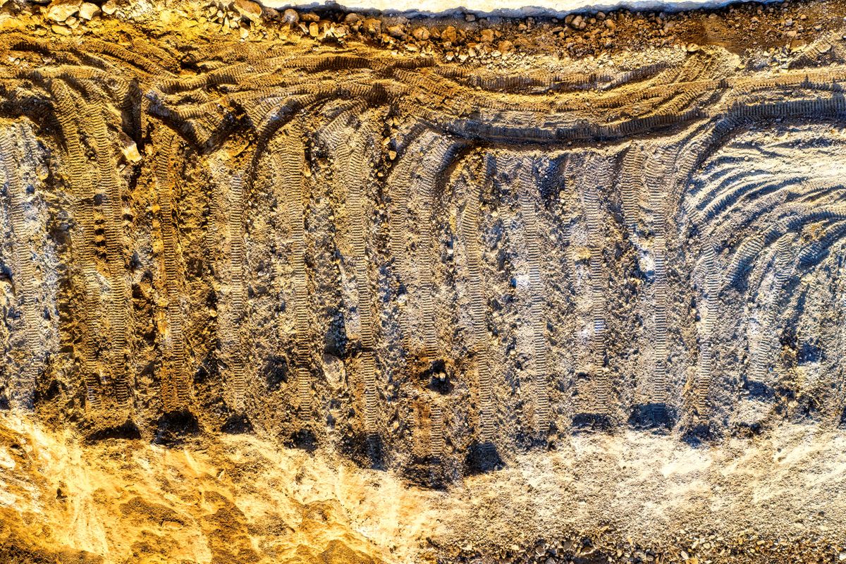Traces de machinerie dans la terre d'un chantier d'excavation
