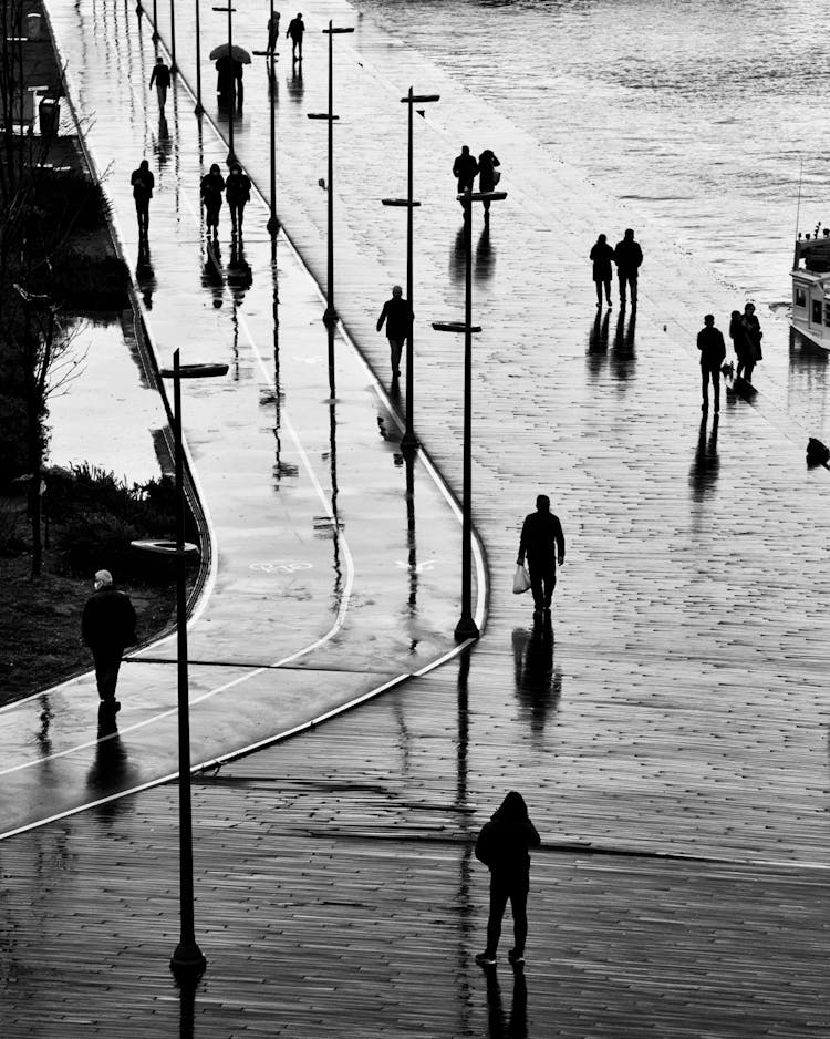 People Walking On A Seaside Promenade In Rain