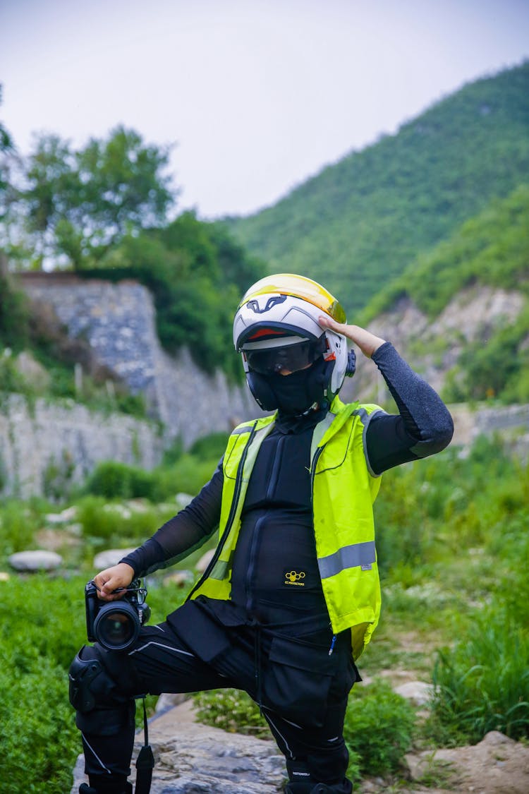 A Man In Wearing Full Motor Gear While Holding DSLR Camera