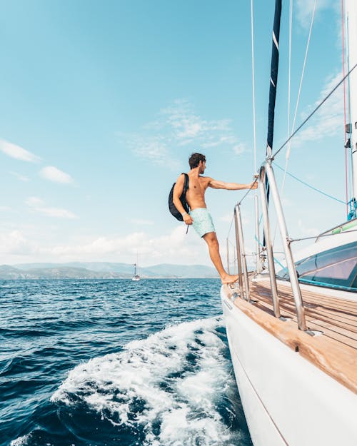 Free Man Standing On The Edge Of Boat Stock Photo