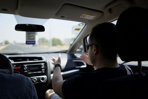 Free Passenger gesturing while conversing during a car journey on a sunny day. Stock Photo