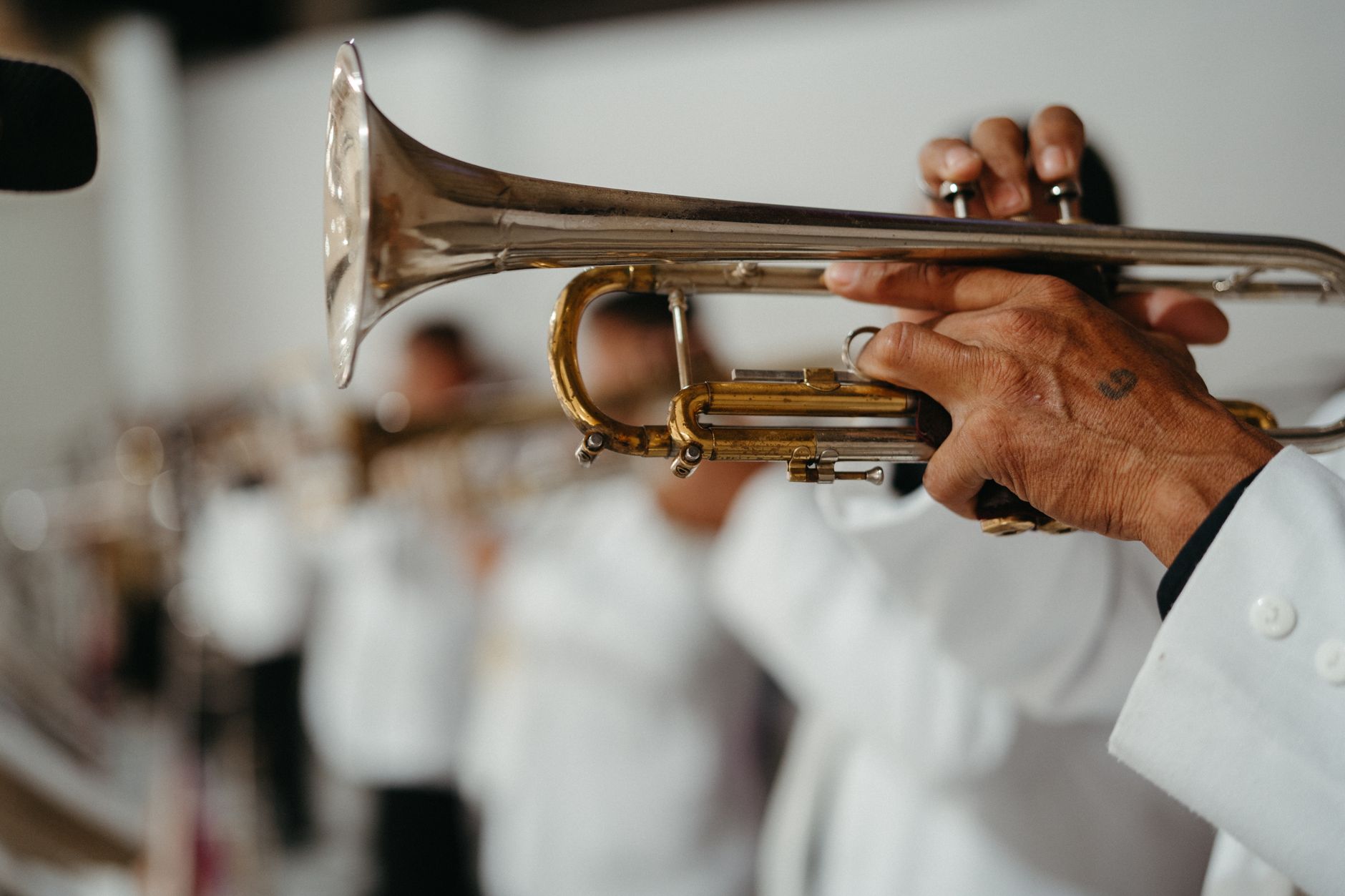 A musician elegantly playing a trumpet in a band, capturing the art of music performance.