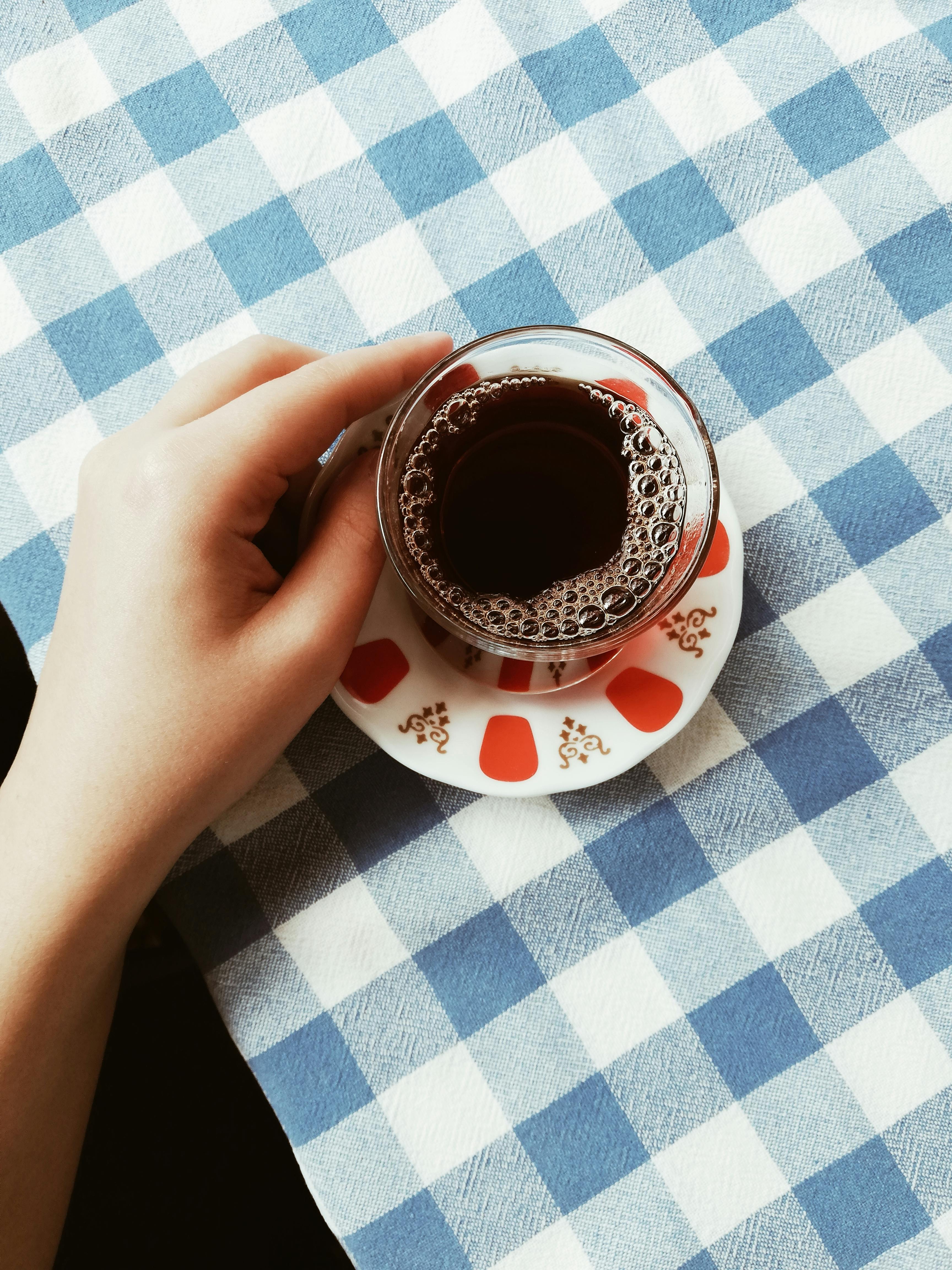 Woman Filling Tea in Cup on Table · Free Stock Photo