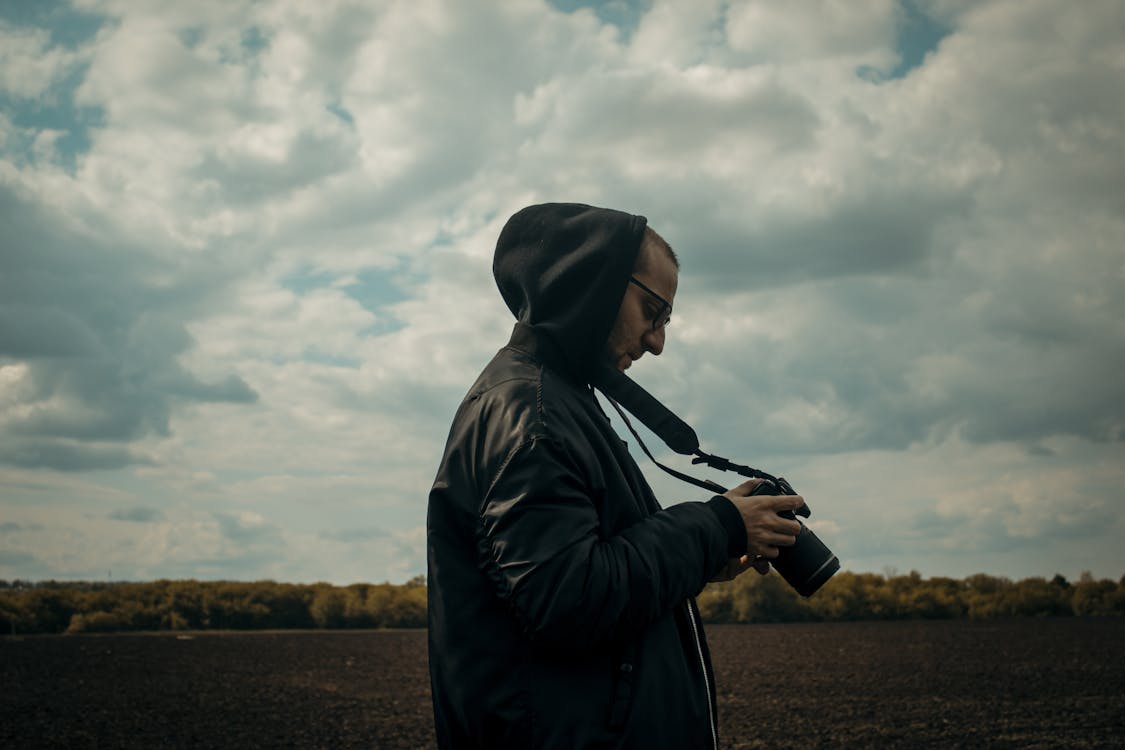 Man in Black Hoodie Holding Black Dslr Camera