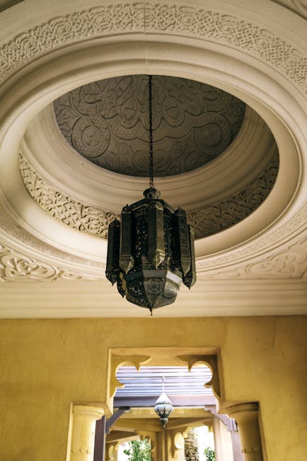 Intricate Arabic designed ceiling with a traditional chandelier in a palace setting.