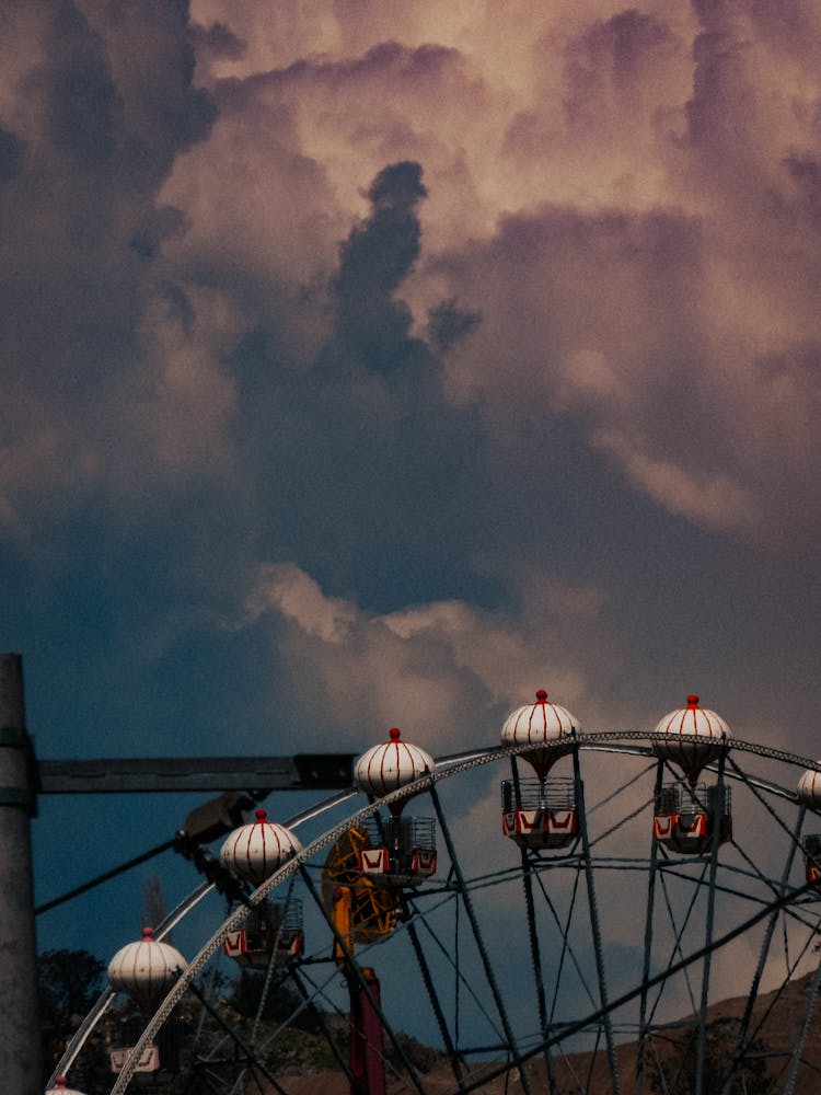 Ferris Wheel Gondolas With Dramatic Sky In Background