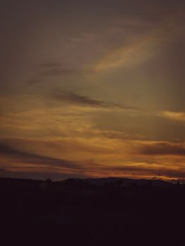 Beautiful sunset with golden skies and silhouetted mountains, perfect for serene landscapes.