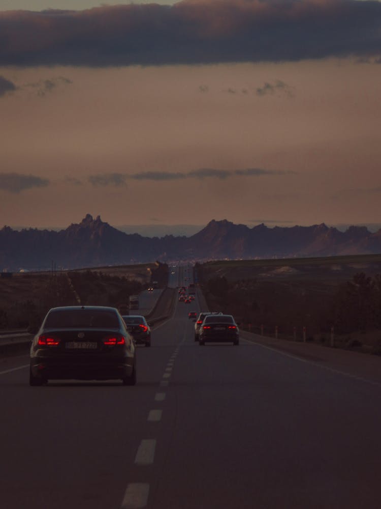 Cars Driving Countryside Road On Sunset