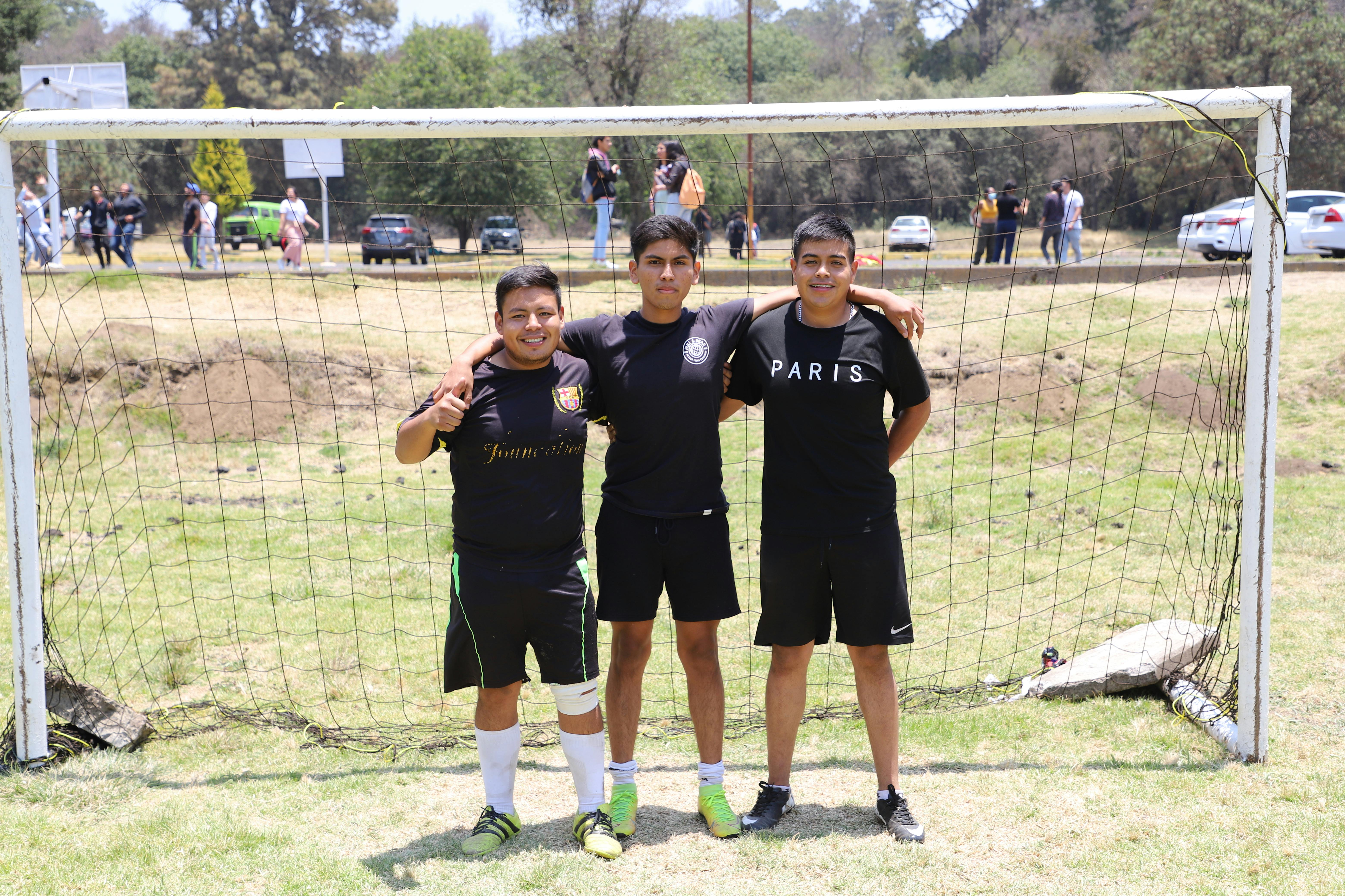 a group of men in black shirt standing near the goal post