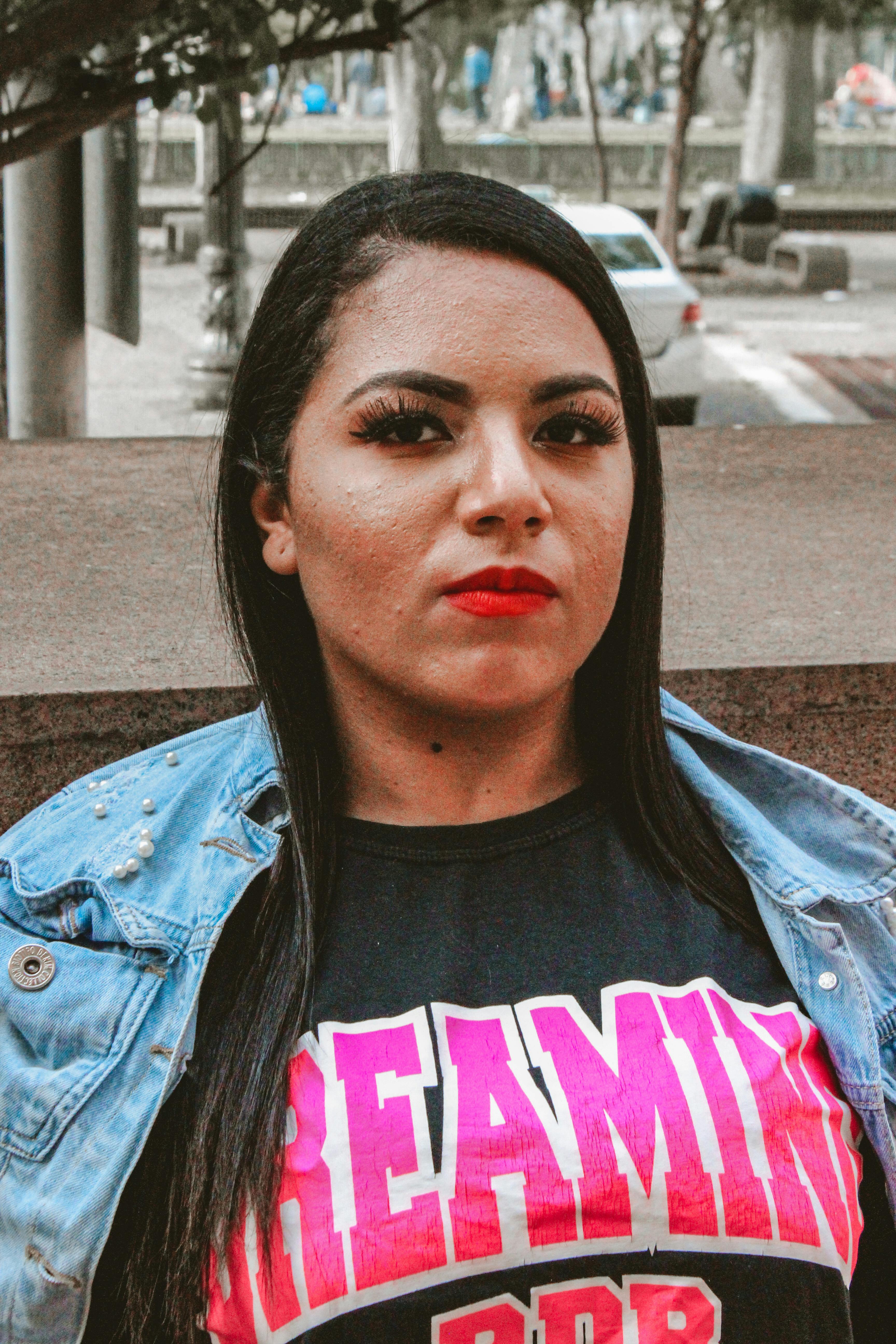 Portrait of a confident woman with red lips in a denim jacket in São Paulo, Brazil.