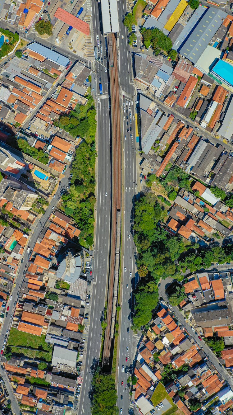 Aerial Shot Of Cityscape With Train Tracks, Street And Buildings