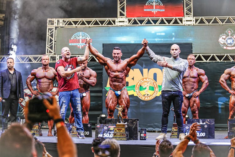 Photo Of A Body Builder Receiving An Award On The Podium