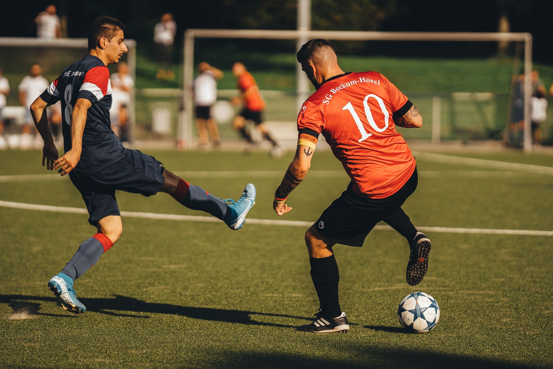 Two soccer players in action on an outdoor field with intense focus.