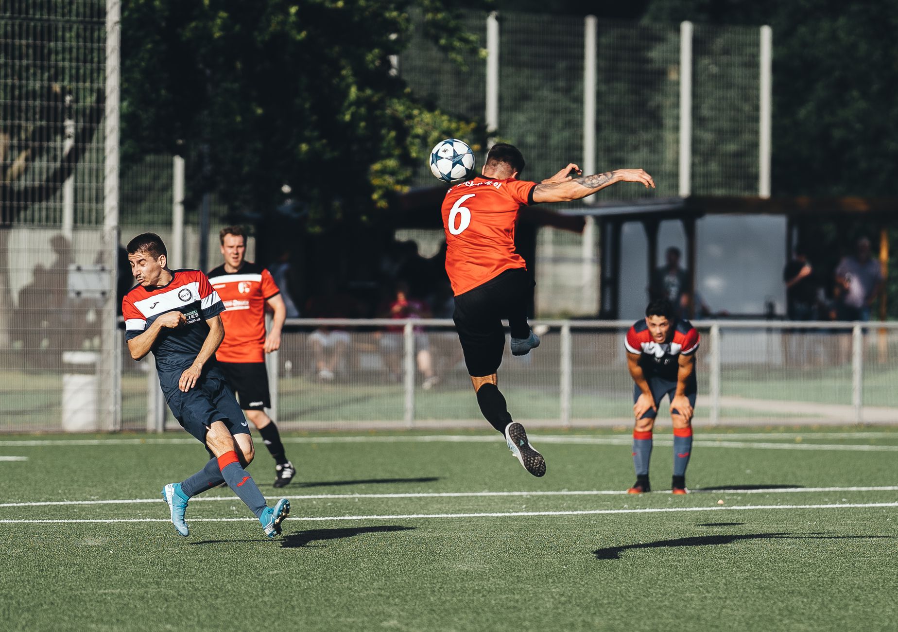 Dynamic soccer match with players in action on a sunny day.