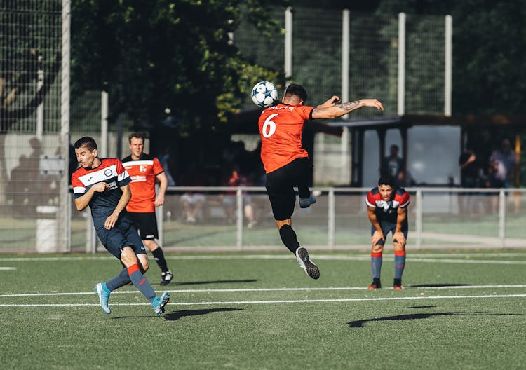 Men Playing Football On Pitch