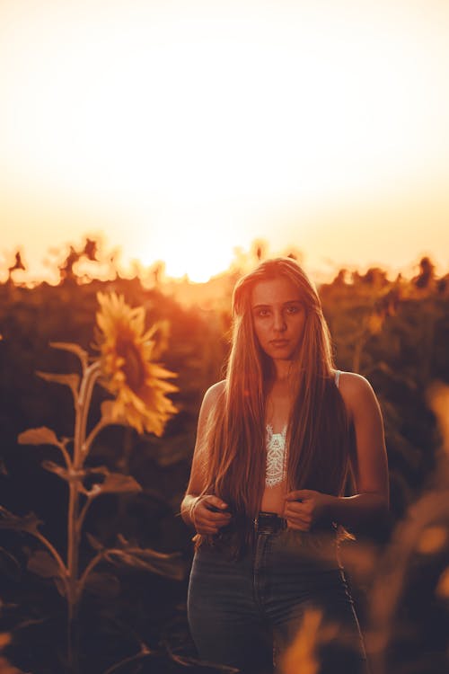 A Woman Standing in a Field at Sunset