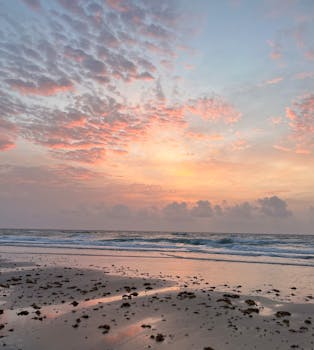 A peaceful sunrise over Boca Raton beach with a colorful sky and gentle waves.