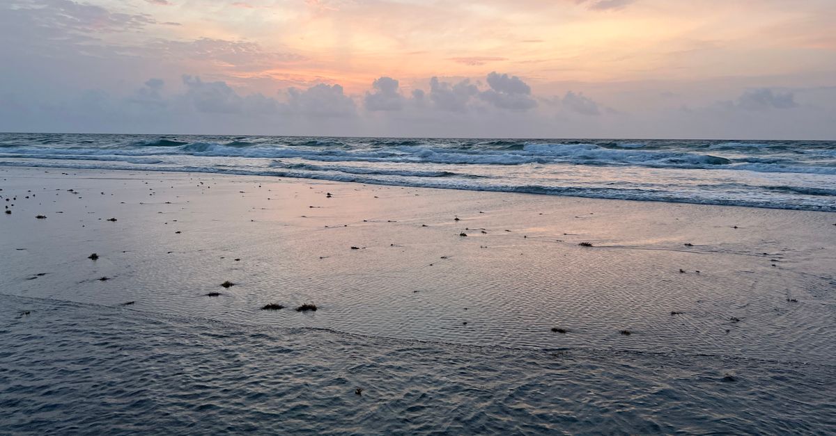 Serene sunset over the ocean at Boca Raton, Florida, with waves and a pastel sky creating a peaceful scene.