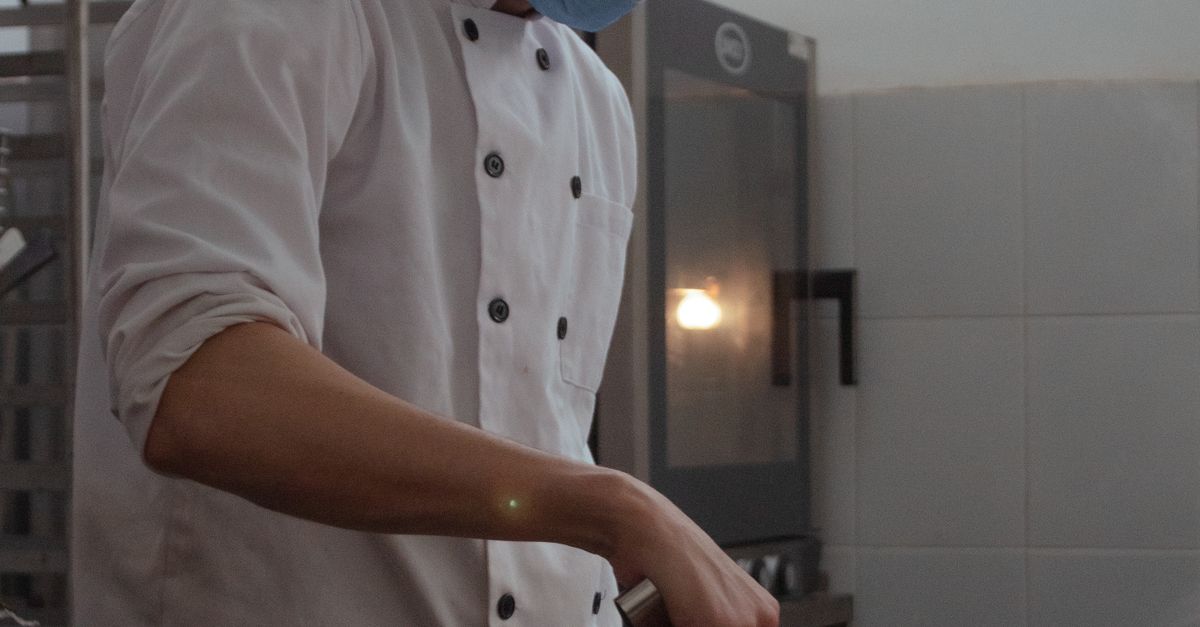 A Chef in a Face Mask Cooking in a Kitchen · Free Stock Photo