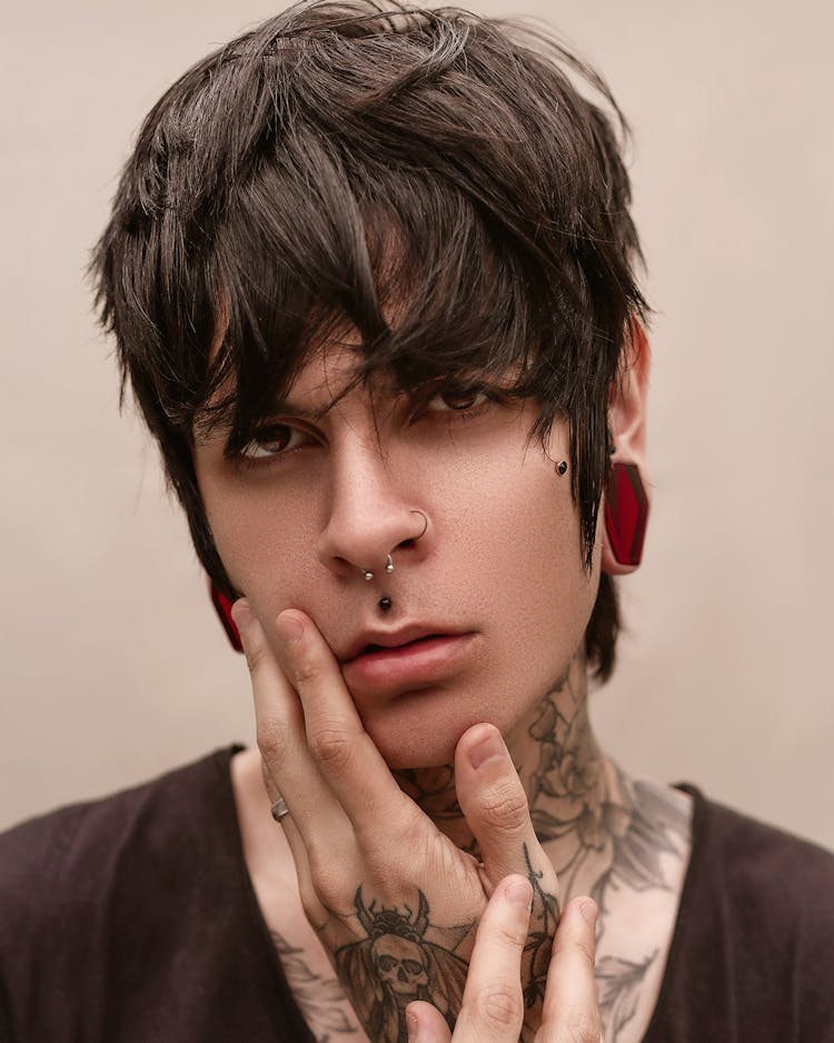 A Man With Nose Piercing And Tattoo