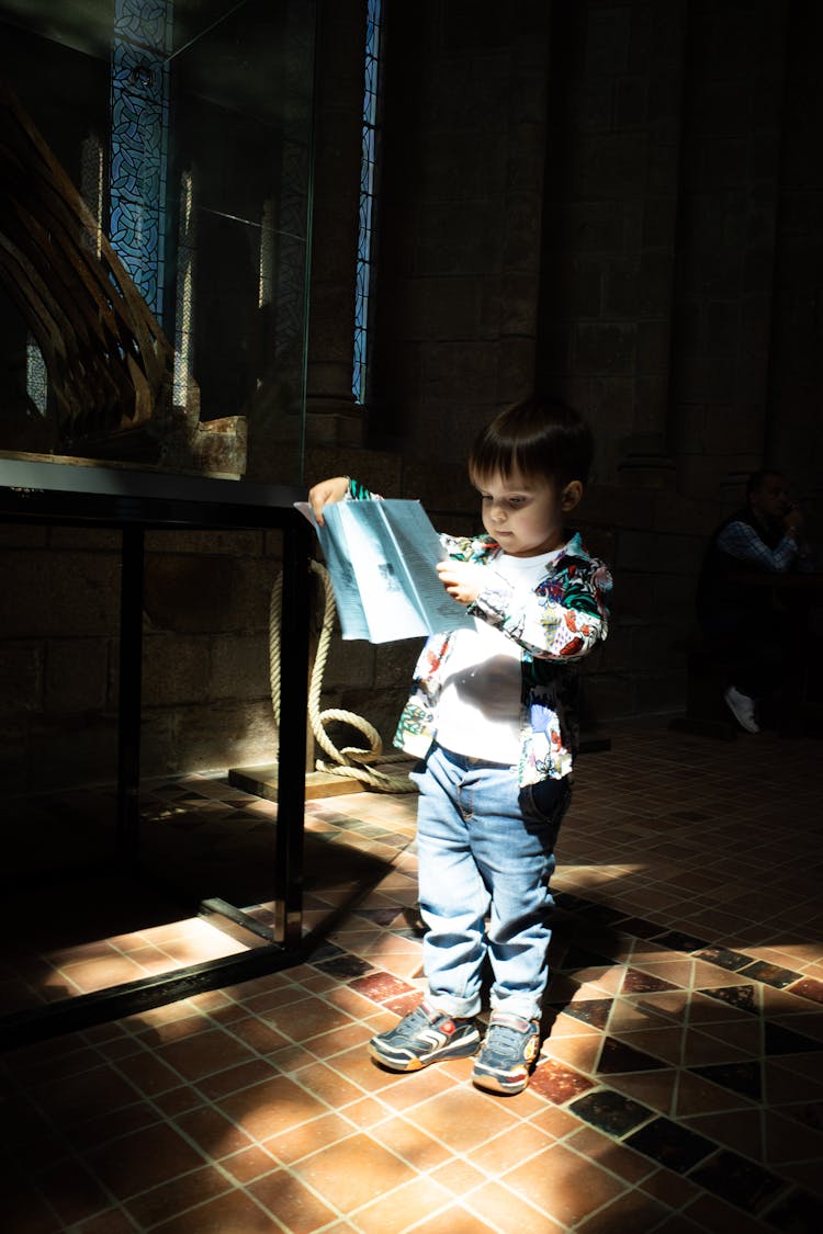 Kid Reading A Leaflet