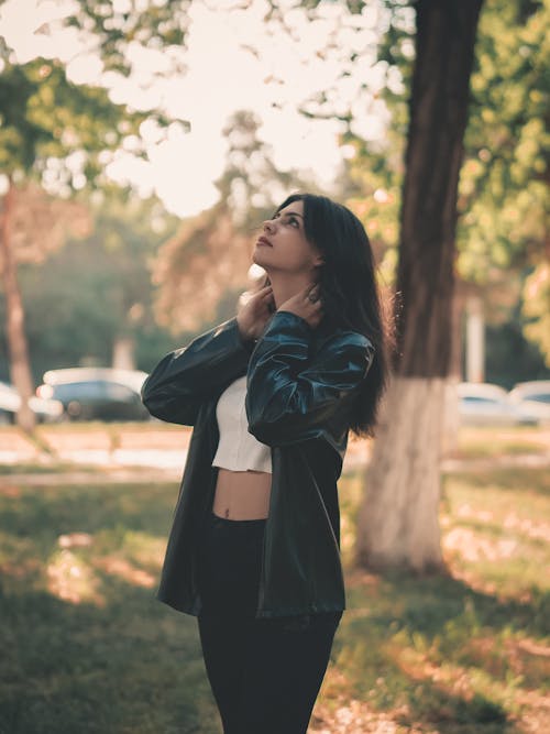 Woman in Black Leather Jacket Standing Near Trees