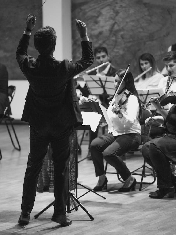 Grayscale Photo Of A Person Conducting An Orchestra