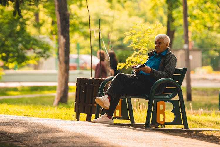 Old Man Sitting On Bench In Park