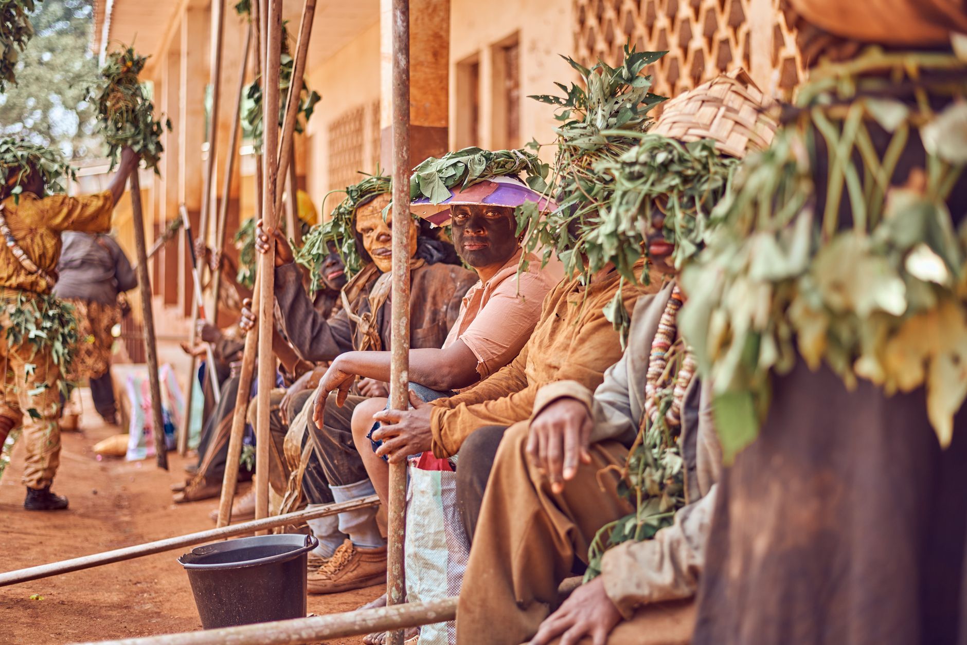 A vibrant African tribal ceremony featuring participants in leaf costumes and traditional attire, celebrating cultural traditions.