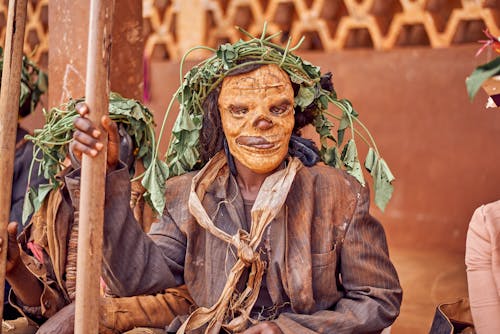 Person in a Mask and Costume Sitting during a Traditional Tribal Ceremony 