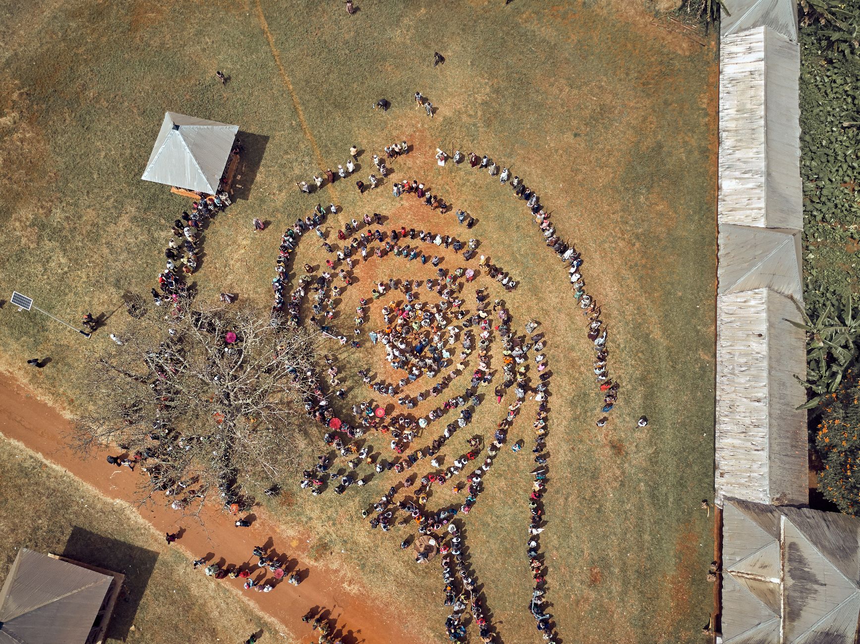 Spiral formation of people at an outdoor event in Batoufam, Cameroon.