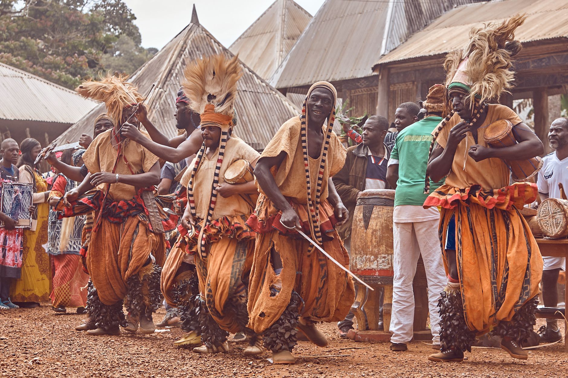 Traditional African dancers performing in colorful outfits during a cultural festival outdoors.