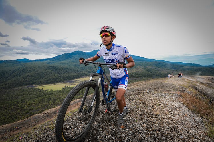 A Man Pushing A Mountain Bike