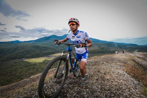 Free A mountain biker pushes uphill on a rugged trail in Mich., Mexico, set against mountain scenery. Stock Photo
