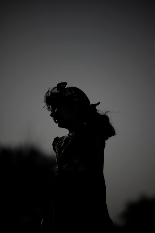 Free Mysterious silhouette of a girl with a twilight sky backdrop. Stock Photo