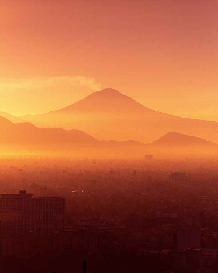 Volcano Behind A City Hidden In Fog