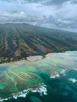 Stunning aerial view of Maui's lush coastline, turquoise waters, and rugged mountains.